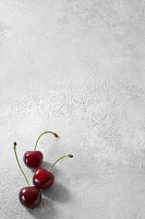 Three cherries on a concrete base