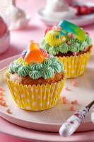 Muffins with colourful icing and jelly sweets