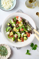 Salad with avocado, tomatoes, lettuce and feta cheese