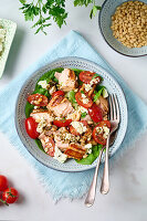 Salad with salmon, tomatoes, spinach, feta and pine nuts