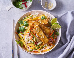 Asian noodle salad with mango strips, fried tofu and coriander