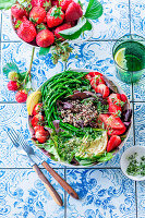 Quinoa bowl with green asparagus, strawberries, and avocado