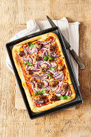 Deep-Dish-Pizza mit Wurst und roten Zwiebeln