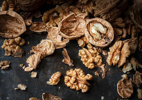 Whole and cracked walnuts on a dark background