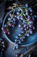 Still life with blue grapes on a dark plate