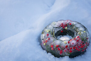 Gefrorener Kranz mit Stechpalme und Mistel im Schnee als Weihnachtsdekoration