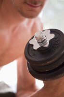 Close up of young man lifting dumbbell