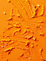 Turmeric powder on an orange-coloured background