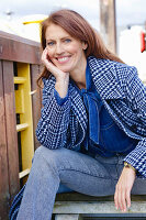 Rothaarige Frau in blau-karierter Jacke und Jeans