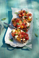 Baked caprese salad with pesto on crostini