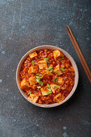 Chinesisches Gericht "Mapo Tofu" garniert mit Frühlingszwiebeln