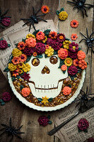 Halloween-Kuchen mit Totenkopf- und Blüten-Dekoration