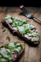 Vollkornbrot mit Rote-Bete-Hummus, Gurkenstreifen und Feta