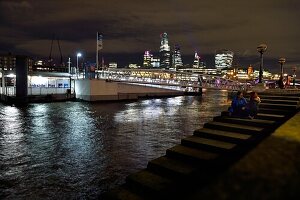 United Kingdom, London, Southwark, lovers on the banks of the Thames at Bankside Pier, the skyscrapers of the City in the background