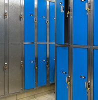 Lockers with blue doors for rent in a public locker room at a recreation centre.