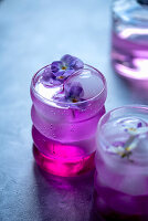 Frühlingscocktail mit Eis und Stiefmütterchenblüten