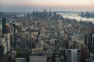 Aerial view of modern buildings against sky in city during sunset