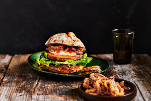 Veganer Burger mit frittierten Zwiebelringen