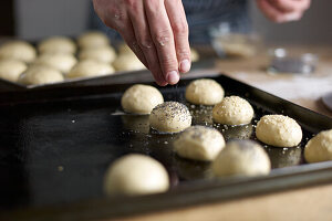 Mini-Buns mit Mohn bestreuen