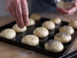 Mini-Buns mit Mohn und Sesam bestreuen