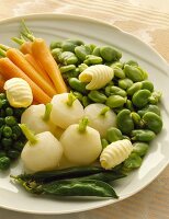 Junges Gemüse mit Butterlöckchen auf Servierplatte (Möhren, Saubohnen, Mairübchen)