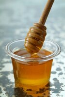 Glasschale mit Honig und Honiglöffel
