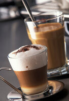 Cappuccino und Kaffee mit Milch in Gläsern