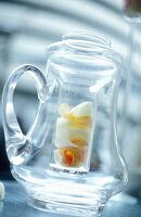 A glass teapot with ingredients for fruit tea