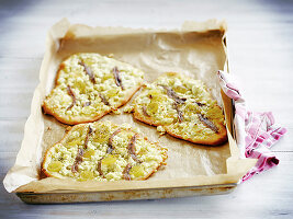 Mini-Pizzen mit Anchovis, grünen Tomaten und Feta