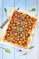 Thin tart with two cherry tomatoes, borage and pansies