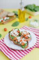 Belegtes Brot mit Babyspinat, Feta und Kirschtomaten