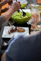 Serving green salad on a plate with grilled meat on a terrace outdoors