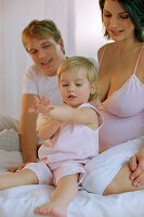 Young family sitting on bed