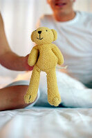 Child's hand holding teddy, close up