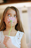 Girl taking a smell at a gerbera