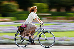 Mature woman riding bicyle, Munich, Bavaria, Germany