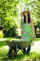 Young woman pushing wheelbarrow