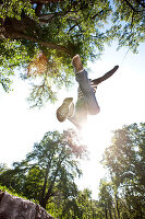 Junger Mann springt im Wald, Steiermark, Österreich