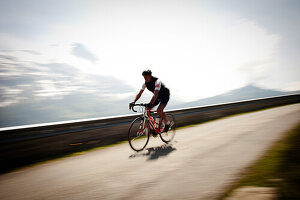 Cyclist on mountain pass, Eiger in the background, descent from Bussalp, Bernese Oberland, Switzerland