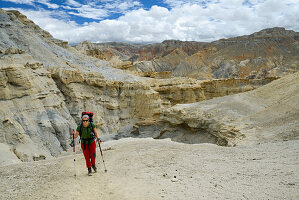Junge Frau, Wanderer, Trekker in surrealer Landschaft typisch fuer das Mustang in der Hochwueste um das Kali Gandaki Tal, dem tiefsten Tal der Welt, Mustang, Nepal, Himalaya, Asien