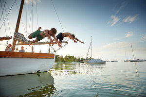 Two teenagers jump from the TWINSTER SIR SHACKLETON ON THE AMMERSEE, Ammersee, Bavaria Germany * Lake Ammer, Bavaria, Germany