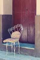 Old iron chair on sidewalk in Havana, Cuba