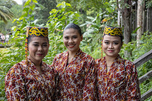 Drei freundliche Frauen in traditioneller Tracht im Sarawak Cultural Village, Kampung Budaya Sarawak, nahe Kuching, Sarawak, Borneo, Malaysia, Asien
