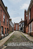 Straßenbild einer Gasse mit Wohnhäusern und Geschäften in Rye, East Sussex, UK