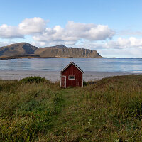 Kleines rotes Haus am Strand von Rambergstranda, Flakstadoya, Lofoten, Norwegen.
