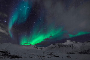 Polarlichter über den Bergen bei Tromsø, Norwegen.