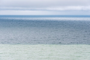 Farbschichten der Ostsee nach Sturmflut, weiße Schicht mit ausgewaschener Kreide im Vordergrund, Kreideküste Møns Klint, Insel Mön, Dänemark