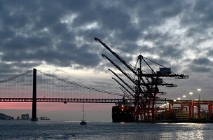 Hafen und Brücke Ponte de 25 Abril am Fluß Tejo in der Abenddämmerung, Lissabon, Portugal