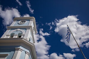  View up to clock tower and Greek flag, Poros, Attica, Greece, Europe 