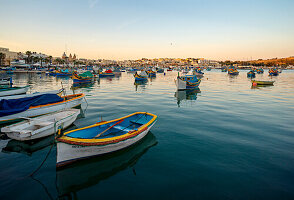  Colorful fishing boats moored in the harbor of Marsaxlokk, Malta, Europe 